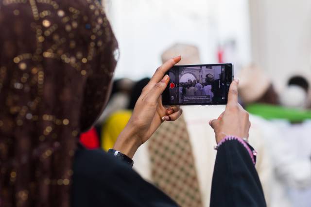 Una mujer hace fotografías con su 'smartphone' durante las fiestas Maulidi en Kenia. rn rn