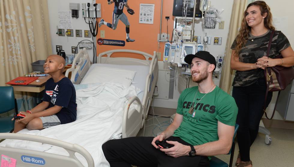 Gordon Hayward juega a un videojuego con un niño en el Boston Children's Hospital.