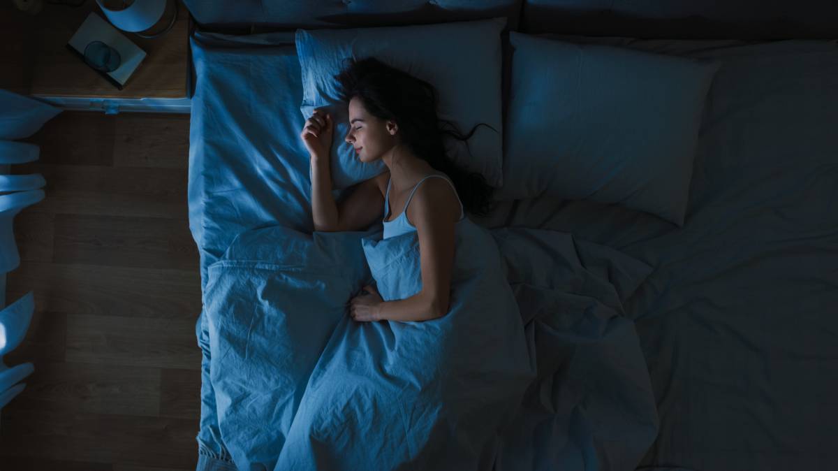 Una mujer duerme en su cama.