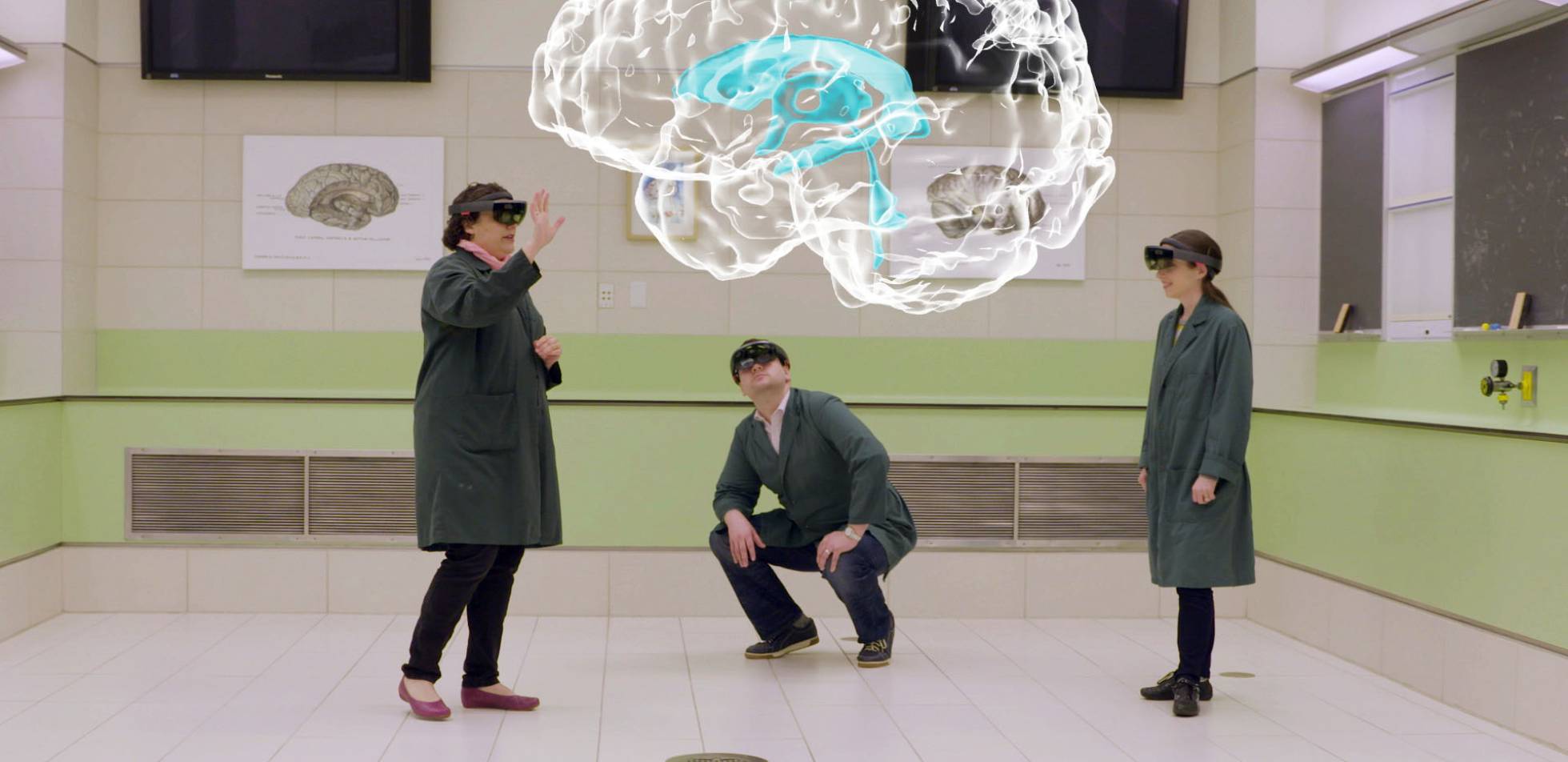 Claudia Krebs y otros dos compañeros visualizan el holograma de un cerebro utilizando dispositivos de HoloLens