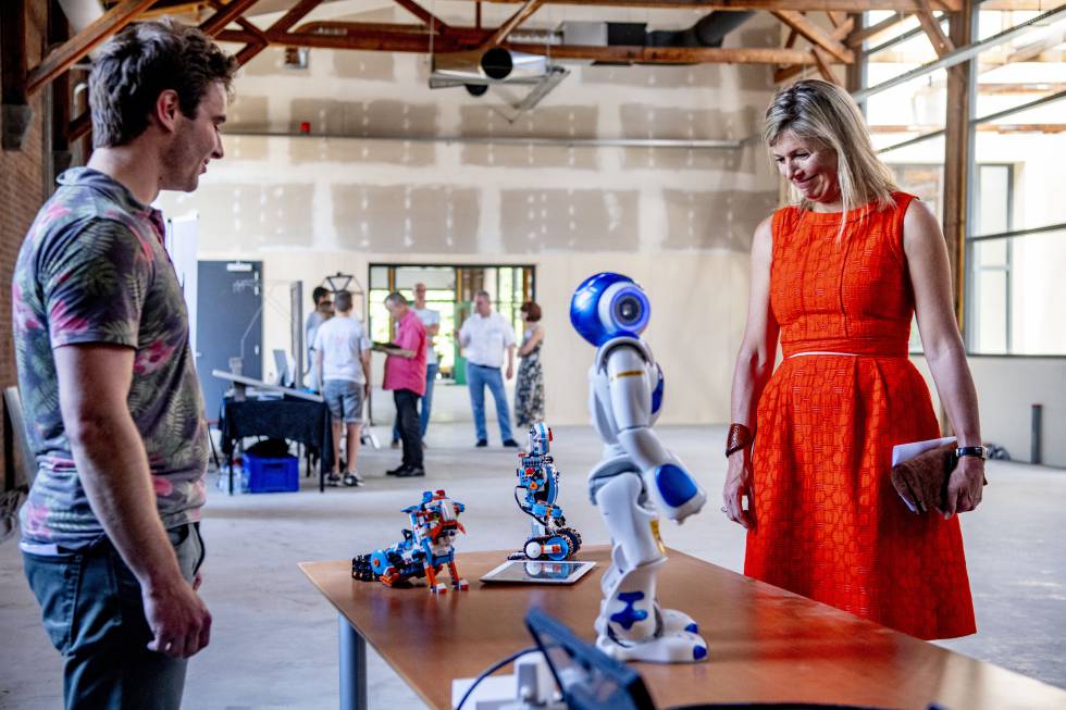 La reina Máxima de los Países Bajos habla con un robot durante una visita a una planta en Apeldoorn.